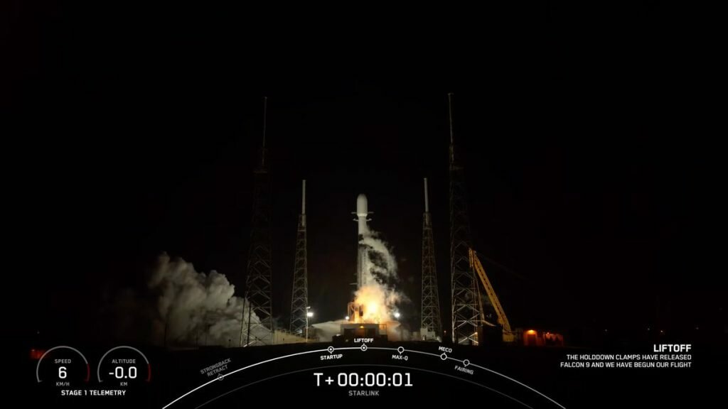 a black-and-white spacex falcon 9 rocket launches into a nighttime sky.